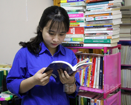 Em Nguyễn Trà Giang bên bộ sưu tập sách của mình.